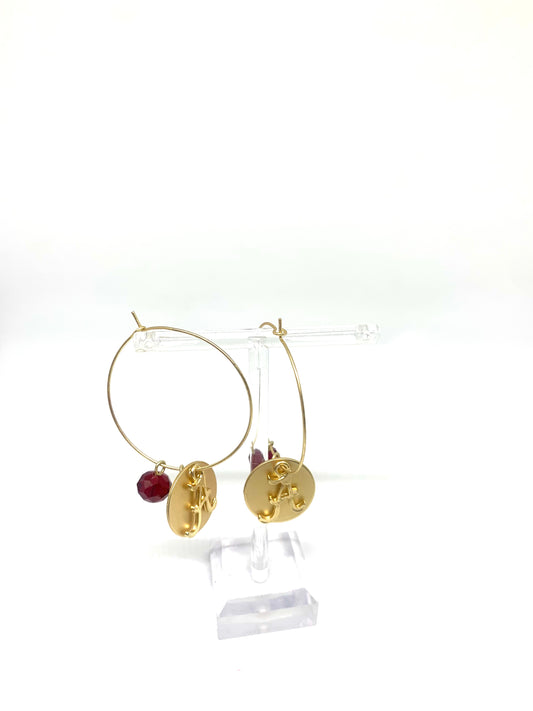 Roll with the Tide in these University of Alabama gold hoops. Show your support for Alabama while being simple and stylish. These gold kidney wire closure hoops feature the University of Alabama logo on a circle charm and maroon bead, Perfect for all your game day looks.